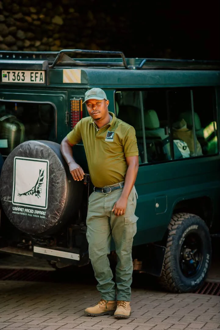 A Lappet Faced Safaris guide beside his safari vehicle